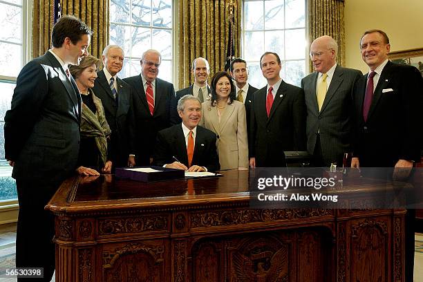 President George W. Bush prepares to sign a bill as Rep. Mark Green , first lady Laura Bush, Sen. Orrin Hatch , Rep. James Sensenbrenner , Rep. Rick...