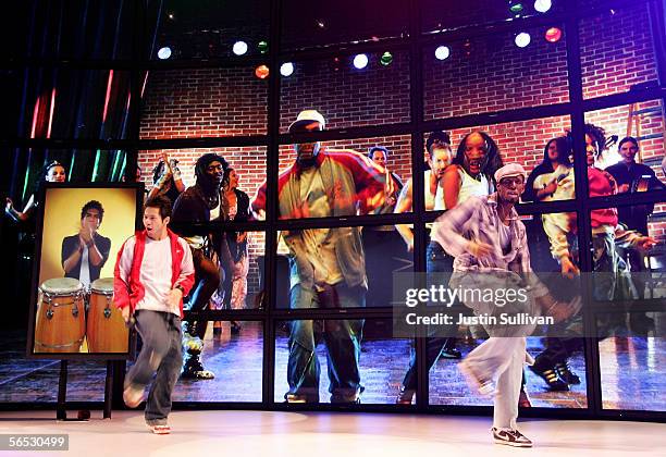 Performers dance in front of a wall of plasma televisions made by Panasonic on the opening day of the 2006 Consumer Electronics Show January 5, 2006...