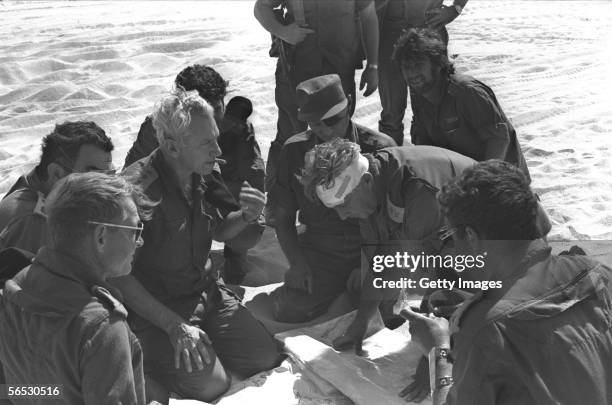 In this handout from the Israeli Governmental Press Office, Southern Command General Ariel Sharon, with bandaged head, confers with Chief of Staff...