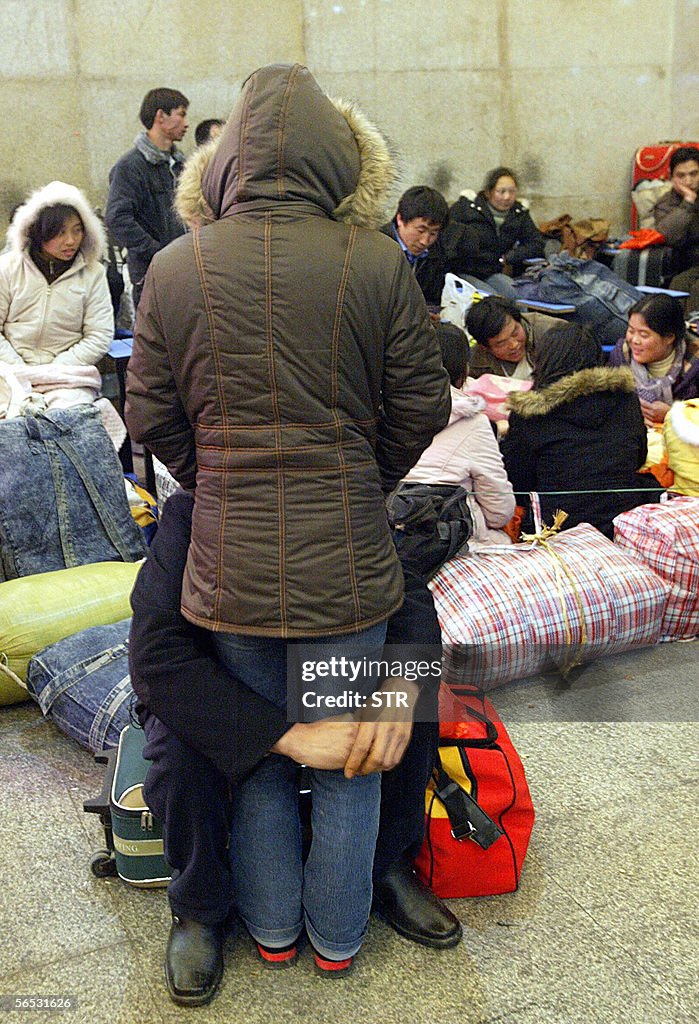 A man embraces a woman as people wait at