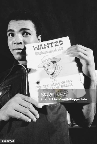 American heavyweight boxing champion Muhammad Ali holds up a tongue-in-cheek Wanted poster with a reward for his own capture, shortly before his...