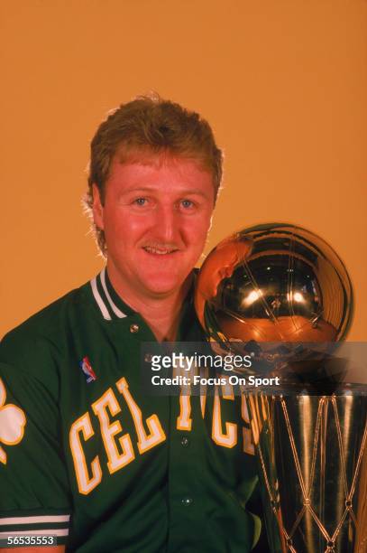 Larry Bird of the Boston Celtics poses with the NBA Championship Trophy circa the 1980's.
