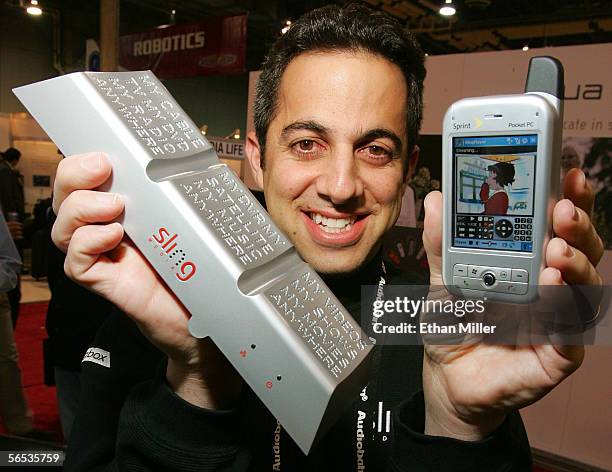 Sling Media co-founder Jason Krikorian displays the Slingbox and a Sprint mobile device with SlingPlayer Mobile software playing a streaming image...