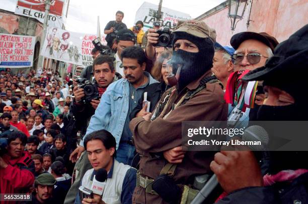 Subcomandante Marcos, leader of the Zapatista National Liberation Army or Ejercito Zapatista de Liberacion National, smokes a pipe on stage, on the...