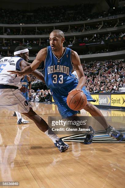 Grant Hill of the Orlando Magic drives against Josh Howard of the Dallas Mavericks during the game at American Airlines Arena on December 16, 2005 in...