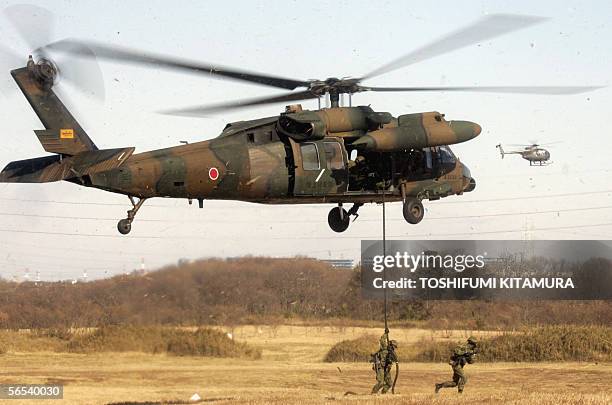 Soldiers gets off from the UH60-JA Blackhawk helicopter during their new year exercise in Narashino city, Chiba prefecture, eastern suburb of Tokyo,...