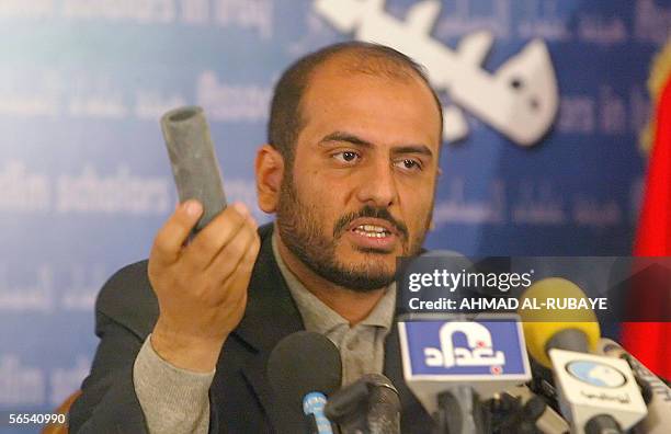 Spokesman for the Sunni Muslim Scholar's Association Muthana Harith al-Dhari holds up a sound grenade during a press conference at the Umm al-Qura...