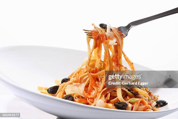 fettuccini pasta with tomato sauce and olives - フェットチーネ ストックフォトと画像