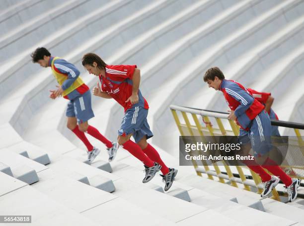 Michael Ballack, Martin Demichelis and Sebastian Deissler run up the stairs of the Al Wasel Stadium during a Bayern Munich training session at the...