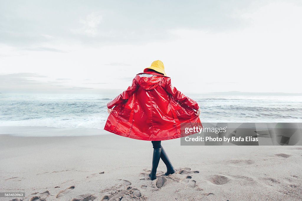 Woman in raincoat on the beach