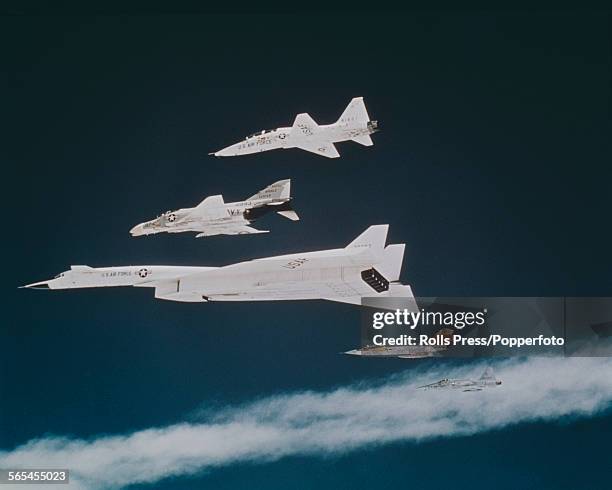 United States Air Force North American XB-70 Valkyrie prototype strategic bomber flies with a fighter escort consisting of a McDonnell Douglas F-4...