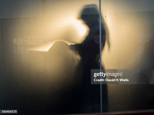 muslim woman prays behind glass - muslim prayer stock pictures, royalty-free photos & images