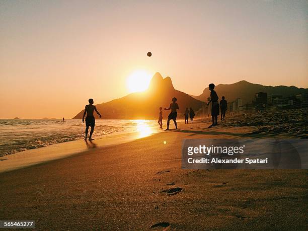people playing football on ipanema beach in rio - rio de janeiro photos et images de collection
