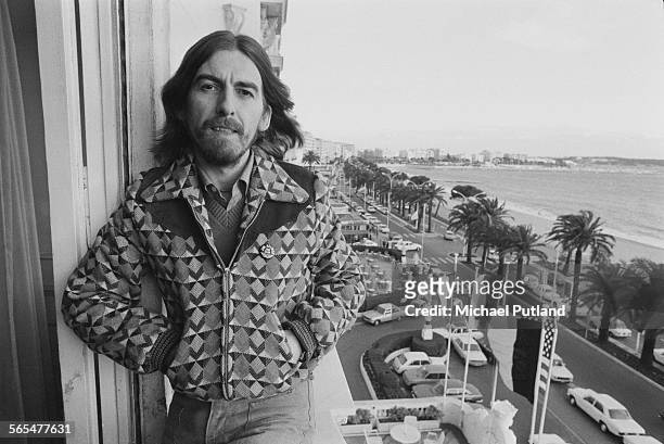 English singer-songwriter, guitarist and former Beatle, George Harrison on a hotel balcony in Cannes, France, 30th January 1976. Harrison is in...