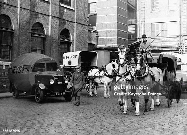 Dans la cour d'un brasseur, sont réunies la voiture hippomobile de Napoléon III de 1870, une charrette de transport en commun de 1900 et un camion de...