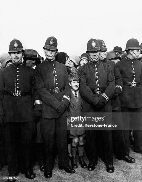 Un enfant s'est faufilé entre les policiers pour être bien placé pour voir passer la procession, à Trafalgar square, Londres, Angleterre,...