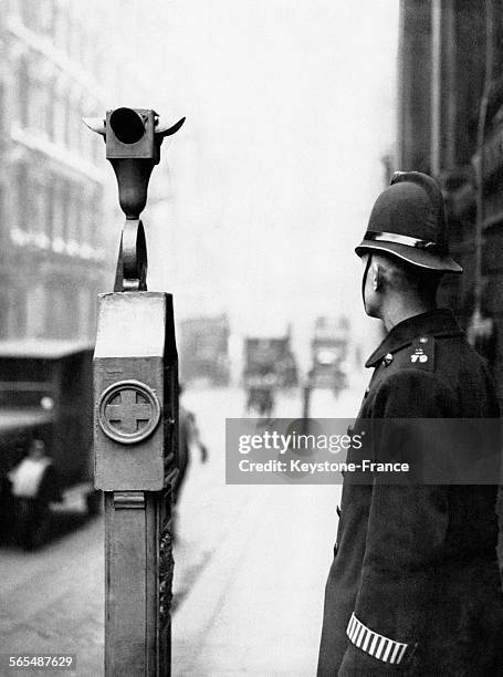 Un policier londonien devant un des équipements permettant de fermer la ville aux fugitifs, à Londres, Angleterre, Royaume-Uni, circa 1930.