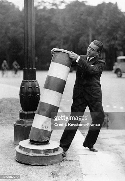 Un homme remettant en place le plot à rayures signalant un danger, à Paris, France, le 4 août 1931.