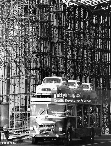 Les voitures sont sur le plateau supérieur, devant un mur d'échafaudage, circa 1960.
