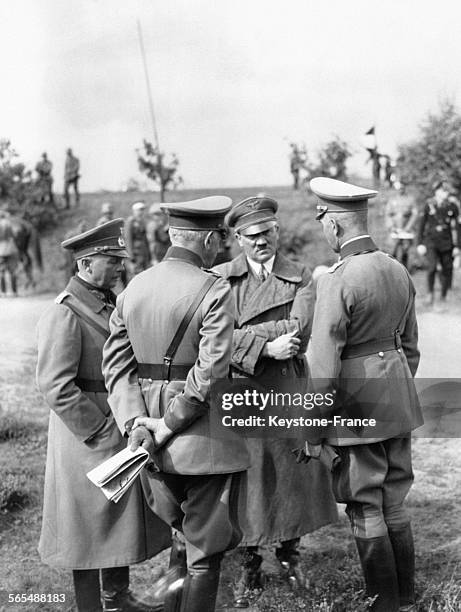 Hitler discute avec ses généraux Werner von Fritsch, Werner von Blomberg, et Curt Liebmann lors d'une manoeuvre militaire sur le terrain, en 1938.
