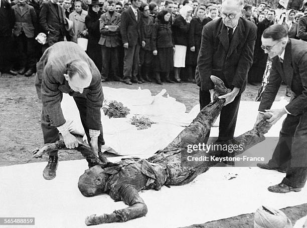 Des civils allemands plaçant des corps de prisonniers juifs russes sur un linge blanc pour leur rendre hommage avant une incinération décente, le 2...