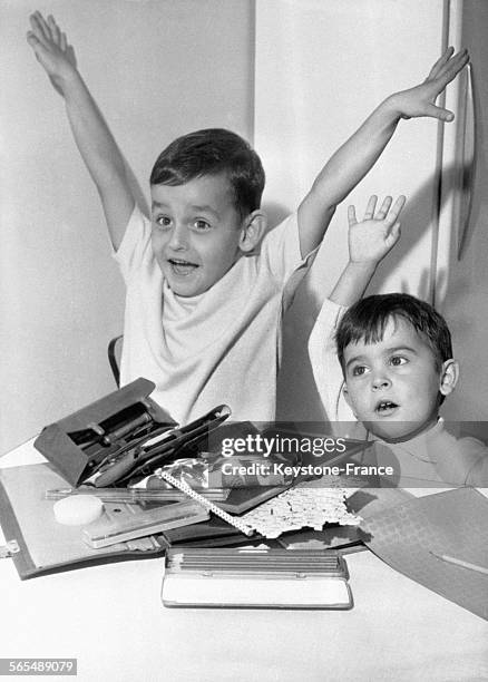 Deux jeunes garçons s'extasient devant leurs fournitures scolaires à l'approche de la rentrée le 14 septembre 1964.