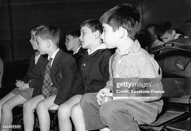 Des écoliers avec leurs cartables écoutent la conférence d'un de leurs camarades âgé de 10 ans sur le Tour de France à la salle de géographique du...