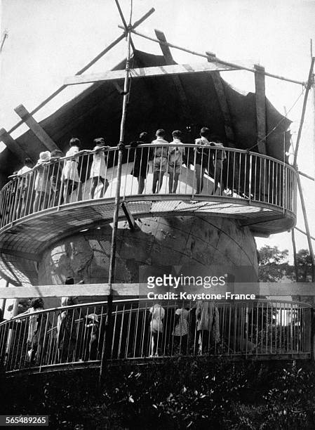 Des élèves sur les passerelles admirent le globe terrestre, plus grande sphère géographique du monde, à l'école en plein air le 23 août 1935 à...