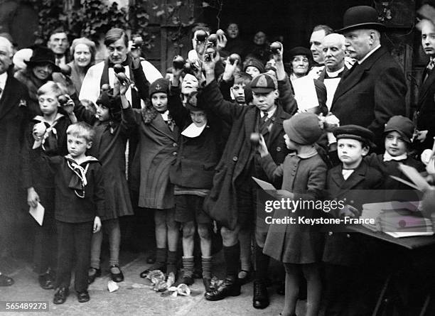 Enfants présentant les fruits qui leur ont été offerts après la cérémonie religieuse des 'Oranges and Lemons' à l'Eglise St Clément des Danois, sur...