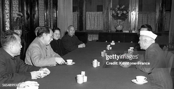 Le Président de la République populaire de Chine Mao Tsé-toung et le Premier ministre de l'Inde Jawaharlal Nehru assis autour d'une table en...