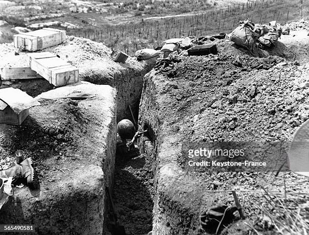 Un soldat devant son trou aménagé dans la paroi de la tranchée pour y loger ses affaires, à Diên Biên Phu au Viêt Nam, le 19 mars 1954.