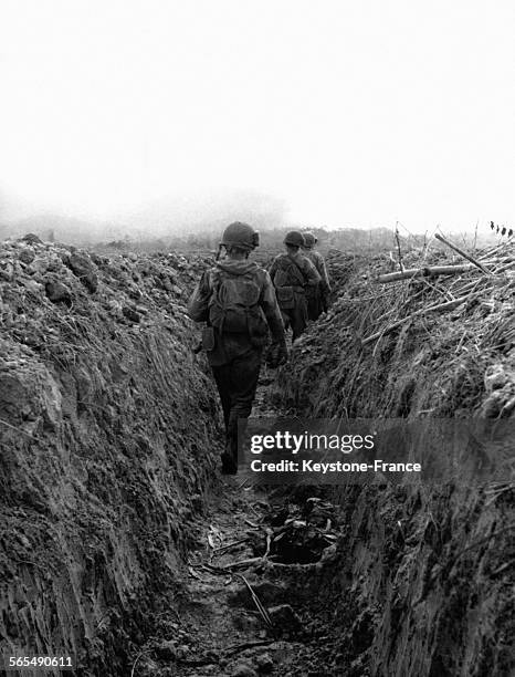 Des soldats cheminent l'un derrière l'autre vers le centre de résistance sud depuis Diên Biên Phu, au Viêt Nam, le 25 mars 1954.