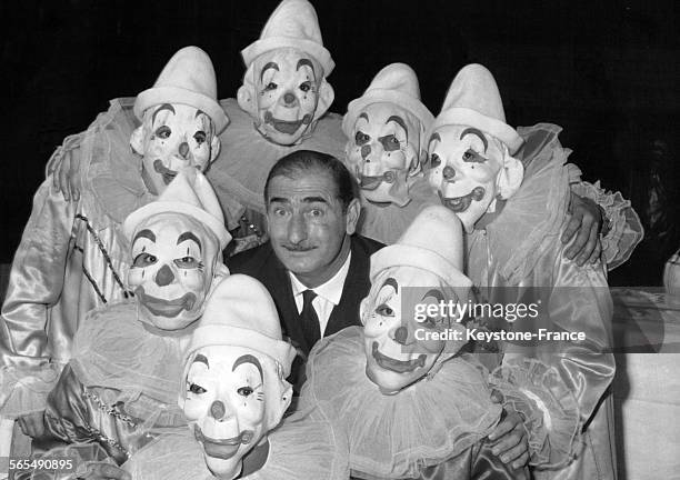 Le clown Achille Zavatta entouré de cascadeurs du cirque Medrano avec lequel il vient de signer un contrat en France, le 4 décembre 1961.