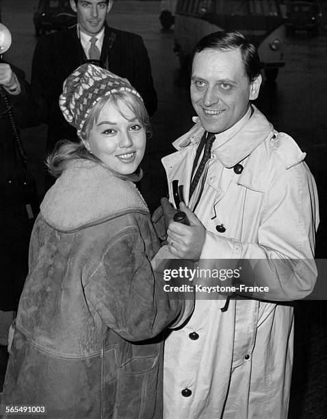 Actrice Mylène Demongeot et son mari le photographe Henri Coste à l'aéroport de Londres, Royaume-Uni, le 2 janvier 1961.