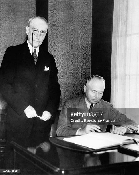 Le duc Charles-Edouard de Saxe-Cobourg et Gotha, président de la Croix-Rouge allemande, signant le registre de l'exposition universelle en présence...