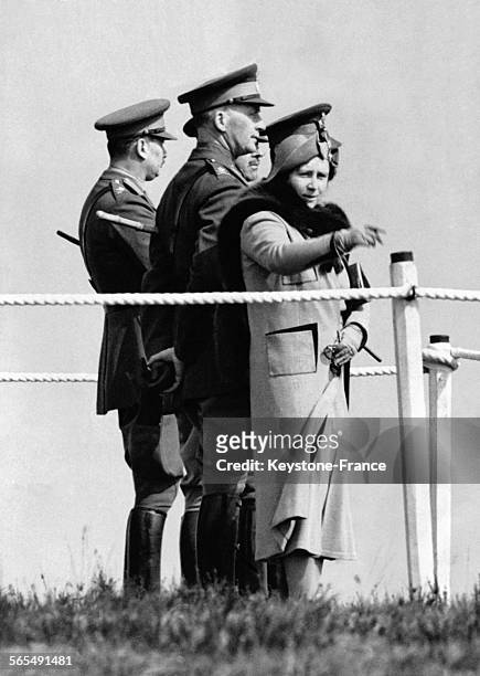 La Reine Elizabeth accompagnée du Duc de Gloucester, en visite au camp militaire, pointe du doigt un élément d'intérêt le 12 avril 1938 à Aldershot,...