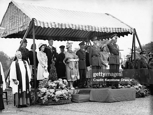 Le Roi George VI, la Princesse Elizabeth, la Reine Elizabeth, la Princesse Margaret et d'autres officiels, sous un auvent reçoivent les saluts des...