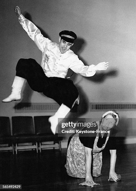 Nicoli Rotschko exécute une danse traditionnelle en sautant par-dessus Mme Grace Churchill of Catford qui lave le sol lors d'une répétition au Royal...