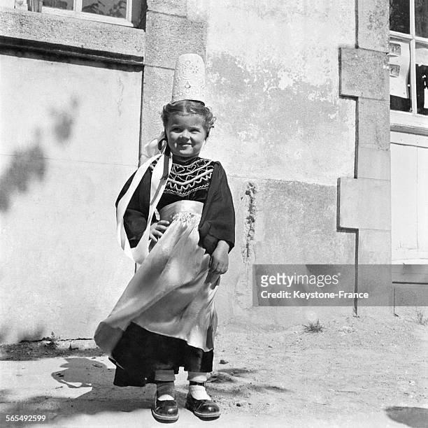 Petite fille portant la robe et la coiffe traditionnelles bretonnes, à Quiberon, France, en 1957.