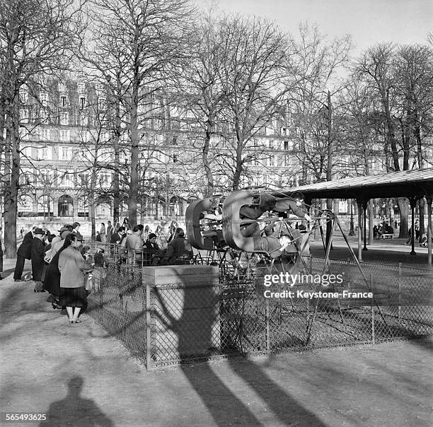 Parisiens profitant des premiers rayons de soleil annonçant le printemps, ici des enfants faisant de la balançoire dans le jardin des Tuileries, à...