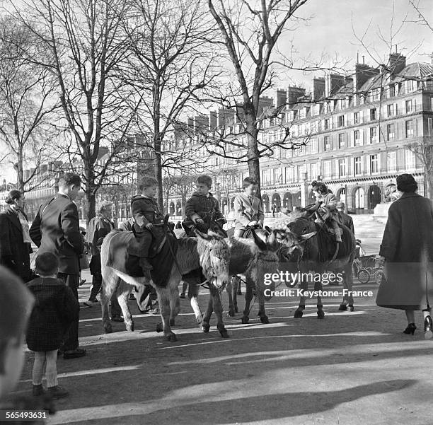 Parisiens profitant des premiers rayons de soleil annonçant le printemps, ici des enfants faisant une promenade à dos d'âne, dans le jardin des...