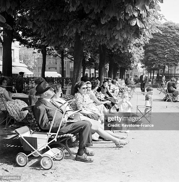 Assis à l'ombre des arbres ou prenant le soleil comme ce vieux monsieur lisant le journal, les parisiens passent le week-end de la Pentecôte dehors...