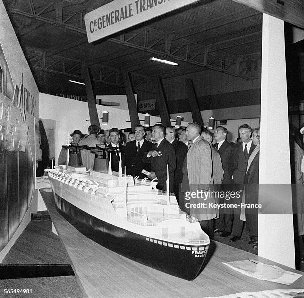 Robert Buron, ministre des travaux publics et des transports, admire la maquette du paquebot France lors de l'inauguration du Salon nautique qui se...