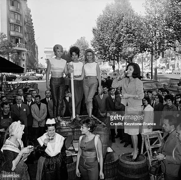 Sur les Champs Elysées, on fête les vins de Provence avec, au centre à terre, portant la hotte, Michèle Moncey, pendant que perchée sur un fût, Maria...