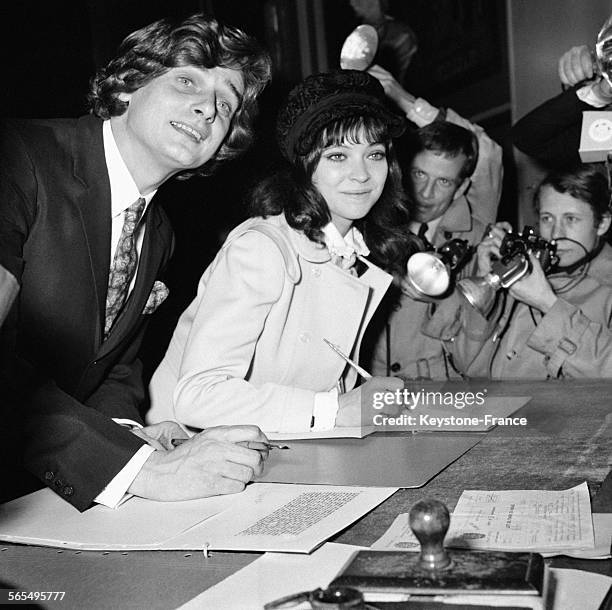 Actrice Anna Karina et son époux, le cinéaste Pierre Fabre, signant le registre de la Mairie du Ve arrondissement à Paris, France le 12 février 1968.