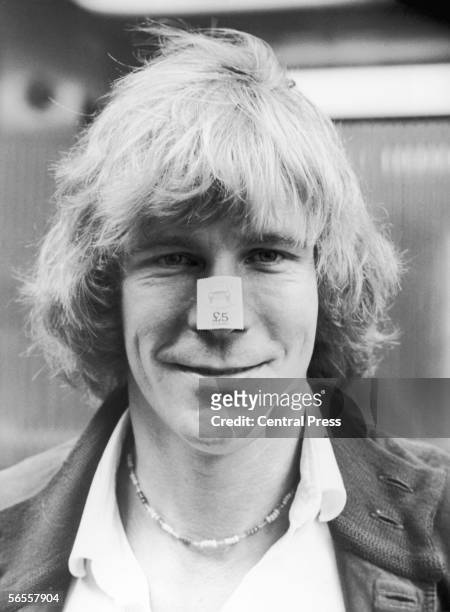 English racing driver James Hunt wearing a vehicle licence stamp on his nose, 11th August 1980. The stamps are part of a Ministry of Transport scheme...