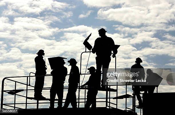 Crew members watch cars in action on the track during NASCAR Nextel Cup Series January Testing on January 10, 2006 at Daytona International Speedway...
