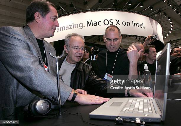 Intel CEO Paul Otellini, former Intel CEO Andy Grove and Apple CEO Steve Jobs look at a new MacBook Pro laptop with Intel Core Duo processor during...
