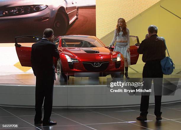 Model Fallon Jamil poses with the Mazda Kabura Concept car on the final press preview day at the North American International Auto show January 10,...