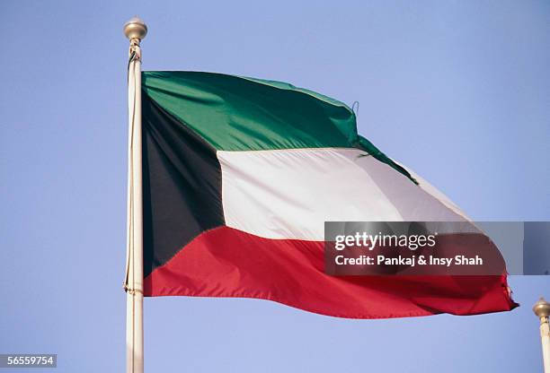 side view of a flag fluttering due to breeze. - kuwaiti flag stock pictures, royalty-free photos & images